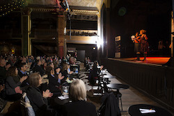 audience members look up at storyteller