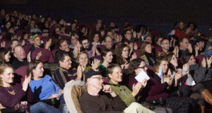 audience members applaud at a show