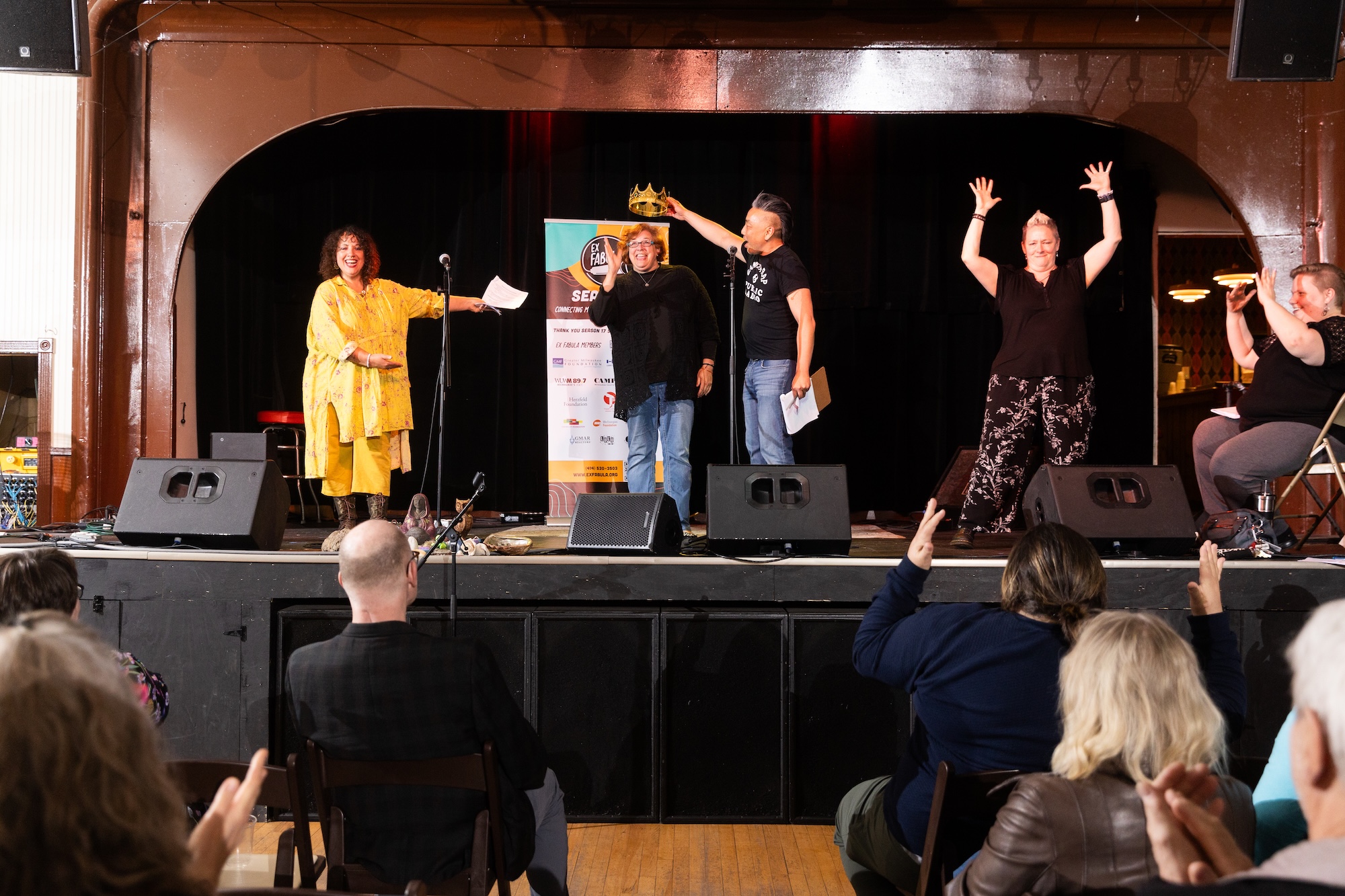 Audience Favorite Julie Sorden has a crown placed on her head by event co-emcee David Lee, while co-emcee Shannon Sloan-Spice and two ASL interpreters stand alongside on the stage at Falcon Bowl.